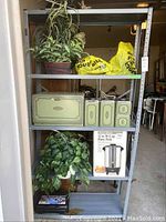 Full shelf view showing two faux plants at top and bottom, retro bread box, matching canisters, original West Bend party perk box, and other miscellaneous items.