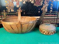 Photo showing both baskets side by side on a green surface with a decorative background screen.