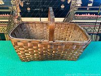 Side view of rectangular oak split woven basket with handle, showing exterior weave pattern and condition.