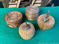 Photo of four woven baskets arranged side-by-side on green felt surface showing overall shape, color, and texture.