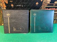 Two Unitsafe leatherette first day cover albums, one black and one green.