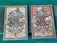 Front covers of Public Ledger Almanacs from 1878 and 1879 showing intricate designs and dates.