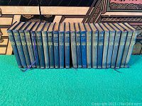 Full set of 21 volumes of the complete works of Sir Walter Scott, showing the blue leather bindings with gold printing on spines.