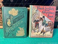 Photo of green 1880-1881 Chatterbox book and colorful 1889-1890 Frank Leslie's Christmas Book side by side on green surface