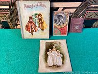 Full view of four children's books including 'Hoods and Furs' and illustrated page, showing condition and colors.