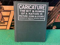 Front cover of the hardcover book showing title label with text 'Caricature The Wit & Humor of a Nation in Picture, Song & Story Illustrated by America's Greatest Artists Special Edition'.