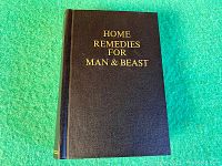 Front cover of the veterinary guide book with gold embossed title text 'Home Remedies for Man & Beast'.