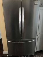 Stainless steel Frigidaire French door refrigerator with bottom freezer drawer, front view, showing exterior condition