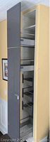 Cabinet door open showing interior with multiple metal slide-out drawers on wheels