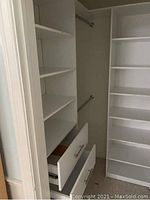 White closet organizer system showing left-side tower with five shelves, two drawers with metal handles, and one hanging rod
