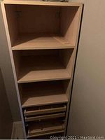Photo of the tall IKEA cabinet showing three open shelves on top and two pullout drawers with dividers at the bottom.