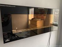 Black glass front wall-mounted electric fireplace mounted on wall