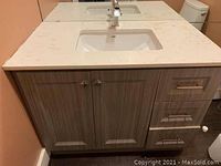 Front view of vanity showing quartz countertop, sink, faucet, cabinet doors and drawers