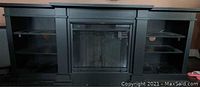 Black wooden cabinet with central electric fireplace and open shelving on each side