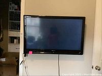 Olevia 42 inch TV mounted on wall with power cable visible.