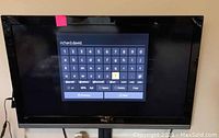 Front view of TCL TV powered on displaying onscreen keyboard with account 'richard.david' typed in.