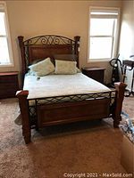 Full front view of assembled queen bed frame with bedding