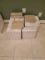 Overall lot view showing stacks of tiles on foam protective packaging