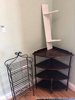 Full view of wire rack, corner table, and wall shelf arranged near the corner of the room, showing details and scale of items