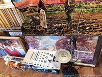 Wide view of tapestry with pastoral scene, framed pictures, eye charts, Star Trek desk lamp, and Star Trek game box.