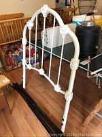 White metal twin bed headboard with floral decorative details and curved design