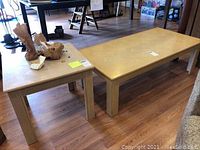 Wooden end table and coffee table set shown side by side on wood floor, displaying size and surface condition including scratches.