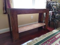 Side view of wood credenza showing rectangular shape, wood grain, and open shelf.