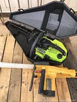 McCulloch Electramac and Poulan chainsaws shown together on wooden pallet, Poulan in carrying case