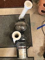 Top-down view showing the full Hayward pool pump with clear strainer lid, PVC fittings, and power cord.