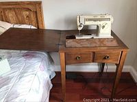 Singer Stylist 533 cream-colored sewing machine mounted in wooden cabinet with drawers.