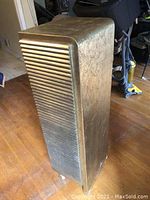 Side angle of tall wooden cabinet showing gold and silver painted crackled finish and ridged side panel.