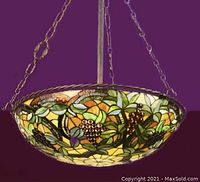 View of the full inverted pendant light showing stained glass shade with grapevine and leaf design, hanging chains, and copper finish hanging bar