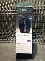 Front view of the original retail box showing the Fitbit Charge HR wristband inside and key feature highlights.
