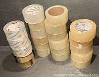 Clear packing tape rolls stacked in four groups, various brands and sizes visible.