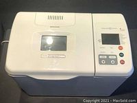 Closed white Williams-Sonoma automatic bread maker with control panel and viewing window on lid.