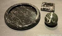 All three marble items displayed together on a neutral surface, showing overall sizes and shapes including platter, box, and sphere.