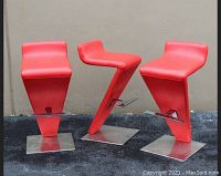 Three red cantilever barstools side by side showing front and side profiles