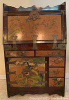 Front view of closed drop-leaf secretary desk showing hand-painted panels and cast brass hardware