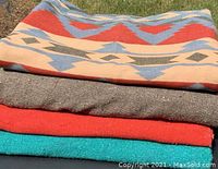 Stack of four vintage southwestern blankets showing color and texture variety