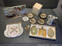 Full view of all items showing beaded purse, stained glass panel, perfume set, angel pin, small porcelain vase, ashtray set, and small decorative porcelain vase.