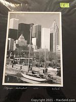 Framed black and white photo titled 'Cityscape - Harbourfront' depicting Toronto waterfront cityscape including boats and buildings. Signed 'J Poole' and numbered 01/75 at bottom margin.