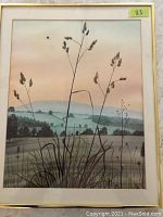 Framed print artwork showing a summer sunset countryside scene with silhouetted grasses in the foreground and rolling hills in the background. Silver metal frame with one mat, overall dimension around 16 by 18 inches.