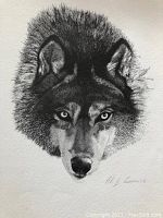 Close-up photo of an unframed black and white print depicting a detailed wolf head, signed by AJ Casson.