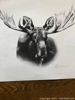 Black and white print of a moose head with large antlers, signed AJ Casson.