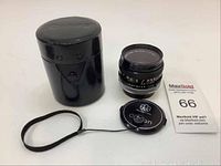 Canon FD 50mm f/1.8 SC lens, black leather cylindrical case, lens cap with strap, and MaxSold info sheet displayed on white background.