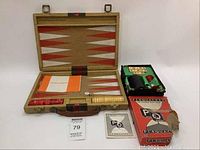 Open backgammon game set showing playing board, pieces, dice, and manual alongside Perquackey game box and components.