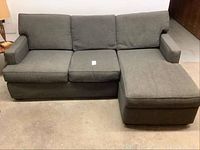 Front view of the grey sectional sofa with chaise lounge on right side, showing three back cushions and three seat cushions.