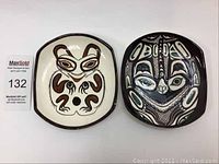 Two Lambert Pottery hand painted decorative plates with West Coast Indigenous art designs, a bear and a dragonfly, shown from top and angle views highlighting shape and paint details.