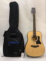 Front view of Tanglewood guitar alongside black nylon soft-shell case