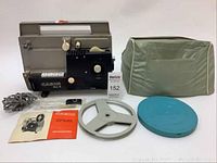 Full lot showing the Cabin All-8 movie projector, film reels, instruction manual, power cord, and carrying cover.